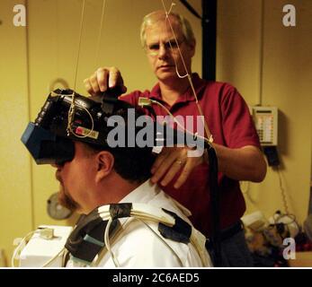 Houston Texas USA, September 18, 2003: A visitor to NASA's Johnson   Space Center wears a virtual reality headset to watch a program that simulates a spacewalk (EVA) to repair nose cone tiles on the NASA's space shuttle. The hands-on demonstration was part of a media tour as the federal space agency prepares for a 'Return to Flight' in 2004, following the loss of the Columbia space shuttle on Feb. 1st, 2003.  ©Bob Daemmrich Stock Photo