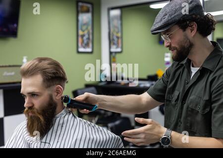 Haircut men Barbershop. Men's Hairdressers; barbers. Barber cuts the client machine for haircuts. Stock Photo