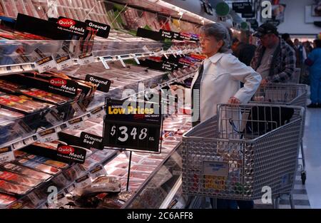 San Antonio, Texas USA, January 21, 2004:  Female shopper looks at huge selection of packaged raw meats in refrigerated meat department at grand opening of 3,000th Walmart store. ©Bob Daemmrich Stock Photo