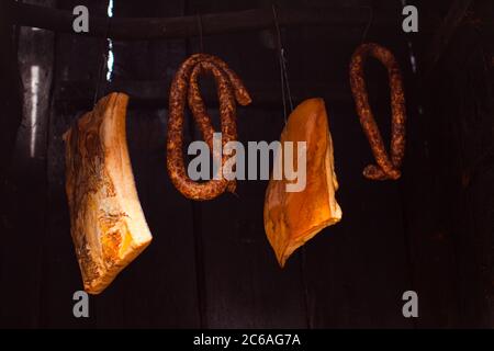 Smoked sausages meat and lard hanging in smokehouse. Stock Photo