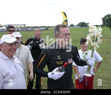 College Station, Texas USA, June 13, 2004: After landing safely from his tandem parachute jump to celebrate his 80th birthday, former U.S. President George H.W. Bush continues the festivities with flowers and vodka given to him by former Soviet President Mikhail Gorbachev (left). Photo credit HO/Golden Knights/Texas A&M/©Bob Daemmrich Stock Photo