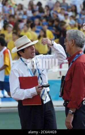 Athens, Greece September 23 2004: Greek track official (left) uses grand hand gestures while talking with the official starter at an evening event during track and field competition at the Athens Paralympic Games. ©Bob Daemmrich Stock Photo