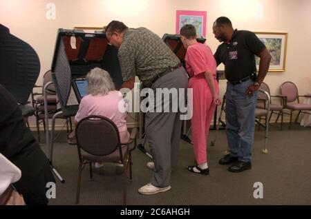Austin, Texas USA, October 19 2004: Early voter who needs assistance sits in a chair in front of an electronic voting machine as she casts her ballot at a senior living facility in the November 2 general election. ©Bob Daemmrich Stock Photo
