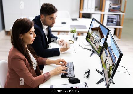 Two Engineers Using Computer Monitor At Office Stock Photo