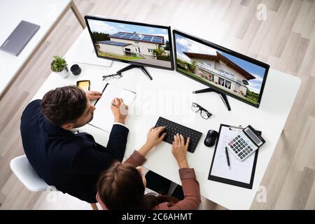 Two Engineers Using Computer Monitor At Office Stock Photo