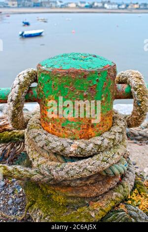 Rusty old cast iron bollard for mooring boats on the harbour at the seaside town of Skerries, county Dublin, Ireland Stock Photo