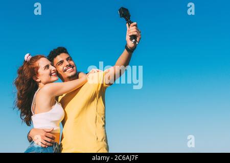 young couple takes a selfie with the sky in the background Stock Photo