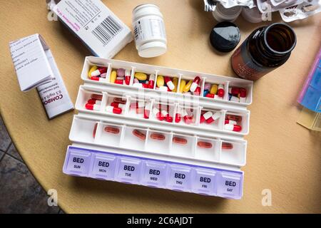 weekly medicines container being filled with pills Stock Photo