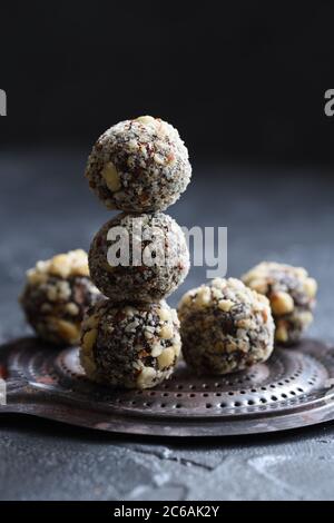 Healthy food concept. Homemade coconut energy balls on old metal tray on black background angle view copy space Stock Photo