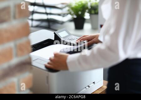 Woman in office prints documents on printer Stock Photo