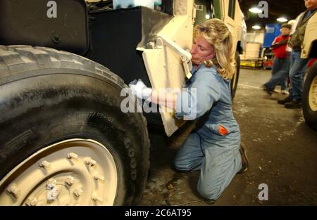 New Boston, Texas USA, November 22 2004: Female worker at the Red River Army Depot rushes to repair, renew and re-armor military Humvees bound for the war in Iraq.  Round-the-clock shifts of mechanics are working at the 33,000-acre military base in northeast Texas. ©Bob Daemmrich Stock Photo
