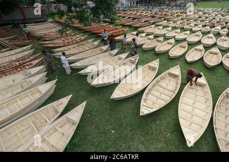 Ghior, Manikgan, Bangladesh. 8th July, 2020. Hand-made wooden boats are displayed for sale at a boat market in Ghior, Manikgan, Bangladesh. The demand for various types of small-sized boats has gone up here with the rise in water level in different rivers and subsequent flooding. The demand for Dingi and Khosa Nauka (small boat) has increased for regular movement of people in flood-prone areas here. Credit: Suvra Kanti Das/ZUMA Wire/Alamy Live News Stock Photo