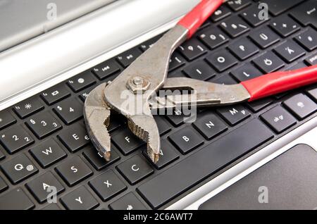 Wrench lying on computer keyboard Stock Photo
