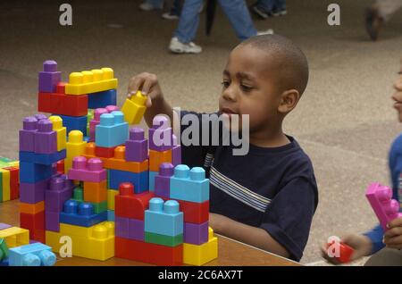 Austin, Texas USA, March 12 2005: During a campus-wide open house at the University of Texas at Austin, African-American children in the engineering department play with plastic stacking blocks. ©Bob Daemmrich Stock Photo