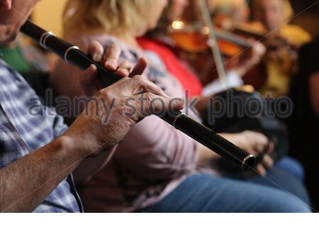 An Irish flute player and other traditional musicians during a Fleadh Cheoil session in Ennis County Clare. Stock Photo