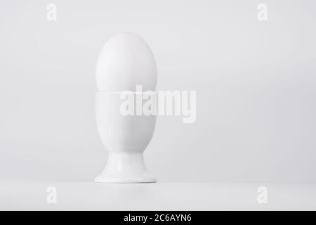 White egg in white egg cup on a white background Stock Photo