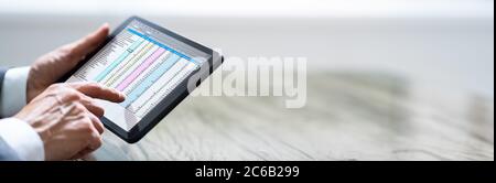 Man Holding Tablet With Online Spreadsheet Data Document Stock Photo