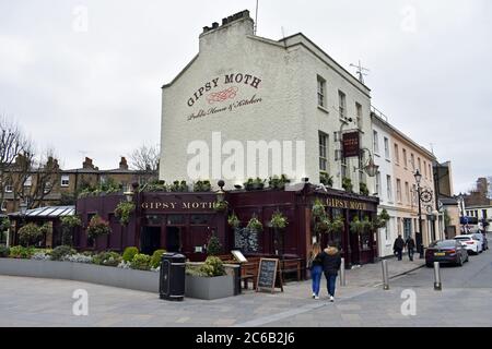 An old fashioned british pub, The Gipsy Moth, in Greenwich, London. The pub has a burgundy lower half with gold writing and a off white main structure. Stock Photo