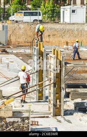 Workers on a construction side of a large apartment complex Stock Photo