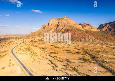 Road crossing the desert landscape of Gheralta Mountains at sunset, aerial view by drone, Hawzen, Tigray Region, Ethiopia, Africa Stock Photo