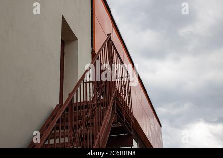 Metal staircase to roof of building on gloomy sky Stock Photo