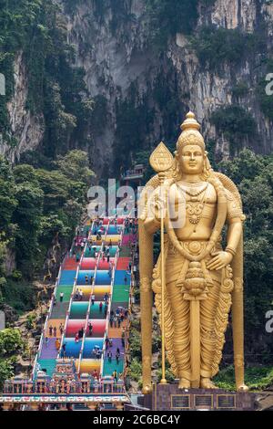 The tall golden Hindu statue of Murugan in front of the 272 steps to the Batu Caves with temples and shrines, near Kuala Lumpur, Malaysia, Southeast A Stock Photo