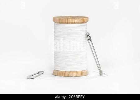 Spool of white thread and two safety pins isolated on white background - 3d render Stock Photo