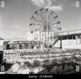 1950s, historical, people riding a 'Big wheel' or 'Ferris Wheel' at a Butlins holiday camp, England, UK. A classic entertainment ride that dates back to the orgins of fairgrounds, the holiday makers ride in pods on the rotating giant wheel. Stock Photo