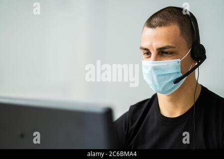 Call Center Telephone Operator In Office Wearing Face Mask Stock Photo