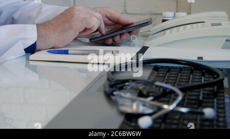 Image with a Doctor in Medical Office Texting Using a Cell Phone, Using Online Network Communication Stock Photo