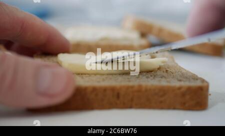 Morning Breakfast with Butter on the Toast, Spreading Margarine on a Fresh Slice of Bread in the Kitchen Stock Photo