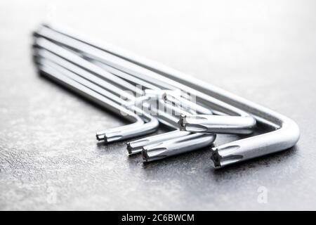 Metal torx screwdrivers on black table. Stock Photo