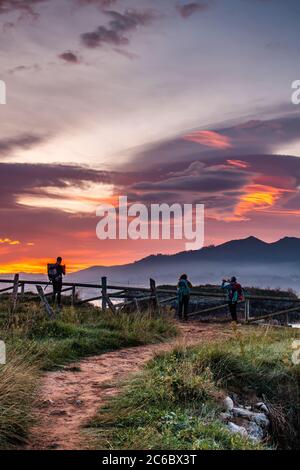 Backpackers doing hiking in sunset. Stock Photo