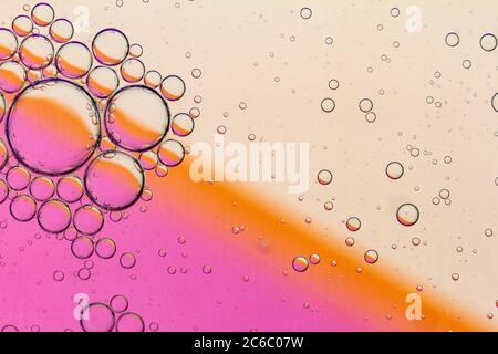 Abstract Background of Oil Bubbles on Water Surface pink salmon colorful palette. Macro close-up shot. Stock Photo