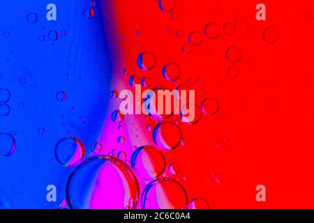 Abstract Background of Oil Bubbles on Water Surface purple red blue magenta colorful palette. Macro close-up shot. Stock Photo