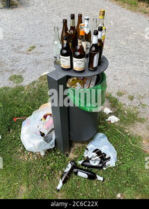 Overflowing garbage can, with lots of garbage, glass bottles next to it, party waste, at a lookout point in the forest, Korte Klippe, Essen, NRW, Germ Stock Photo