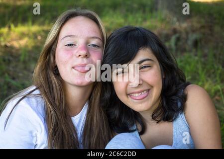 Two teenage girls fool around in front of the camera. Stock Photo