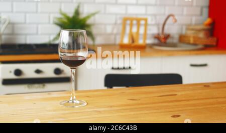 Close up of glass of wine on table in kitchen. Stock Photo