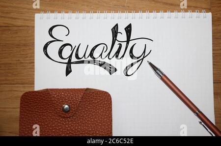 Equality word lettering with pen and brown wallet. Inclusion tolerance concept. Stock Photo