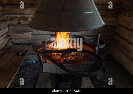 Open fire grill in a log hut Stock Photo