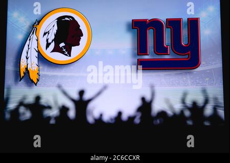 Washington Redskins vs. New York Giants. Fans support on NFL Game. Silhouette of supporters, big screen with two rivals in background. Stock Photo