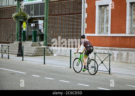 Lourdes, France - June 18, 2018: A man is riding a bicycle on a city street Stock Photo