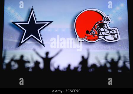 Dallas Cowboys vs. Cleveland Browns. Fans support on NFL Game. Silhouette of supporters, big screen with two rivals in background. Stock Photo