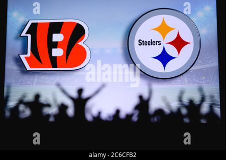 Cincinnati Bengals vs. Pittsburgh Steelers. Fans support on NFL Game. Silhouette of supporters, big screen with two rivals in background. Stock Photo