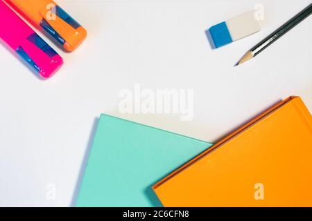 Office or school related object on a white background: coloful notebooks, highlighters, rubber, pencil Stock Photo