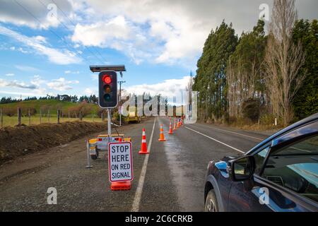 Road works in progress so vehicles are stopped at the red light as it is temporarily a single lane, New Zealand Stock Photo