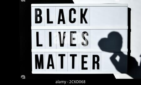 BLACK LIVES MATTER text with deep shadows of heart on a black and white background. Protest against the end of racism, anti-racism, equality Stock Photo