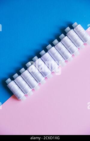 Row Of WhiteThread Spools On Table flatlay Stock Photo