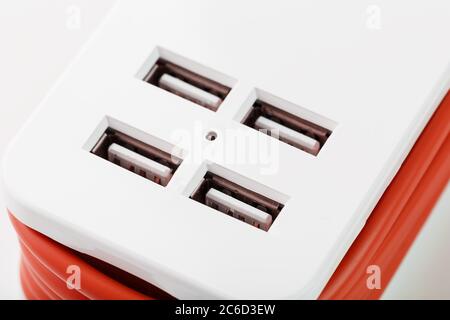 Extension Socket with USB Port on white background for charging phones and electronic devices, red power cord. Stock Photo