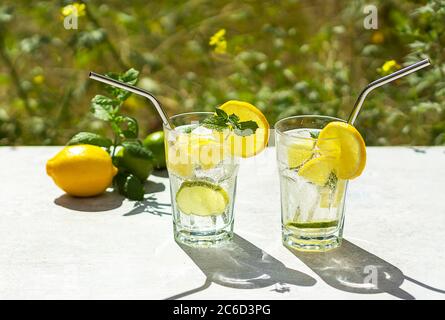 Refreshing cold lemonade drink with lemon, lime slices, mint, and ice cubes Stock Photo